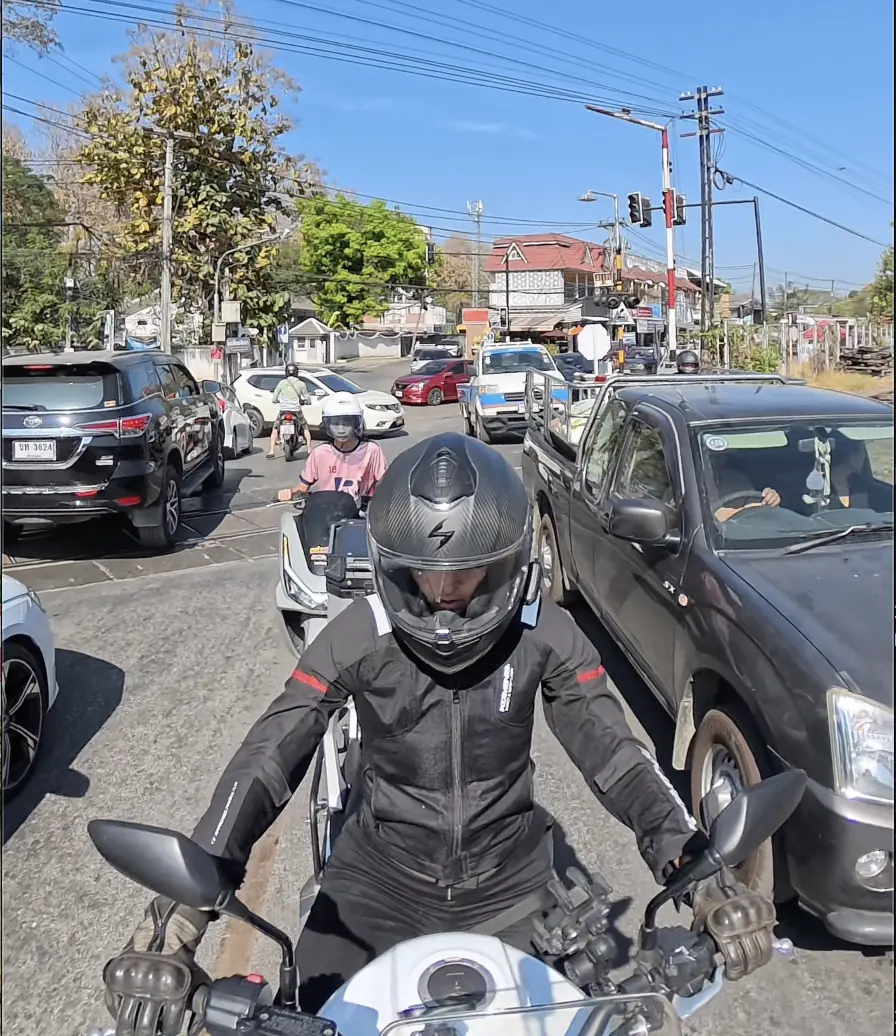 Female rider in Chiang Mai city traffic, motorbiking in Thailand